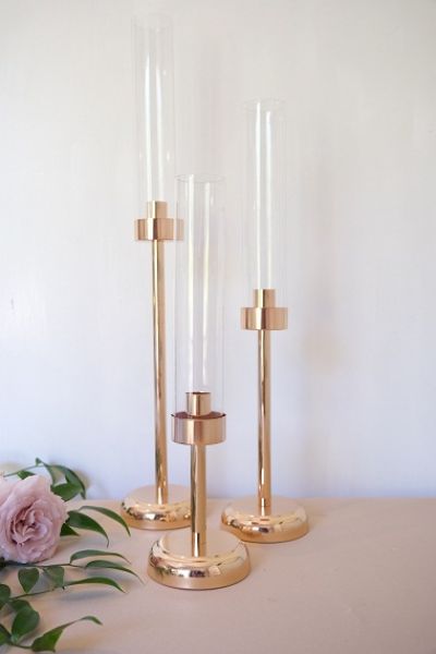 KOD 064<br><strong>ŚWIECZNIK ZŁOTY Z KLOSZEM</strong><br>Wymiary: 37 cm, 48 cm, 57 cm<br>Ilość na stanie: 36*<br>*możliwa większa ilość<strong><br>Cena wypożyczenia: 12 zł</strong>