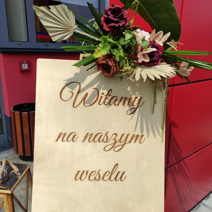 KOD 482<br><strong>TABLICA POWITALNA DREWNIANA</strong><br>Wymiary: 57 x 74 cm<br><strong>Ilość na stanie: 1</Strong><br><strong>Cena wypożyczenia: 20 zł</strong>